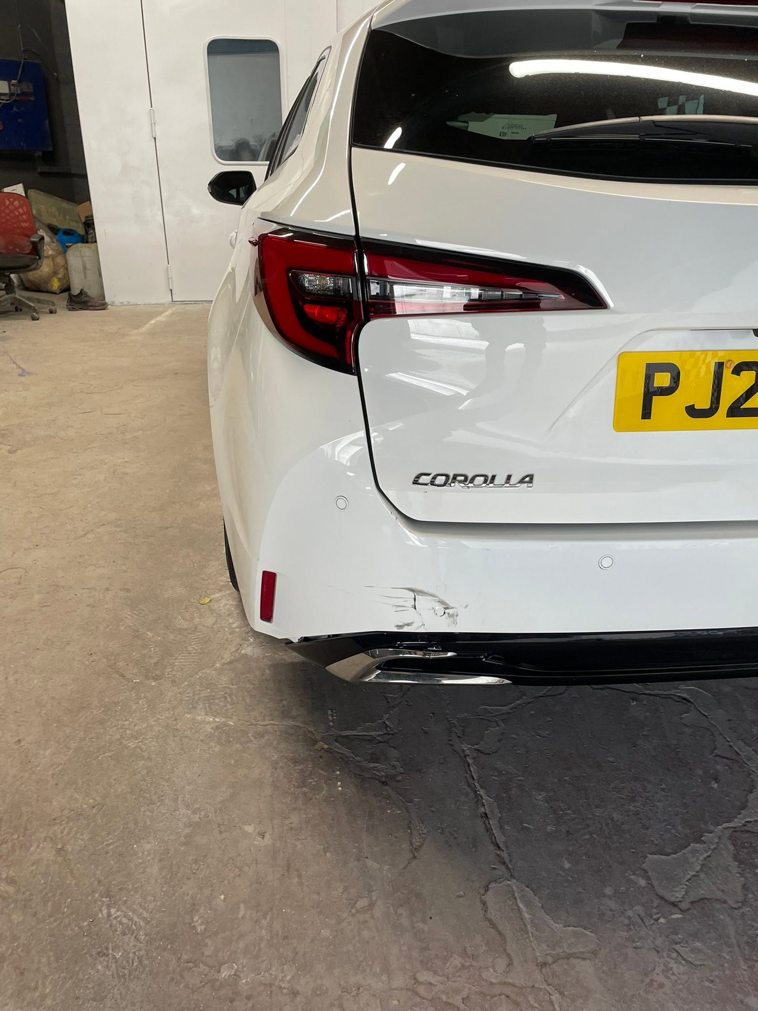 White Toyota Corolla rear quarter view in the workshop