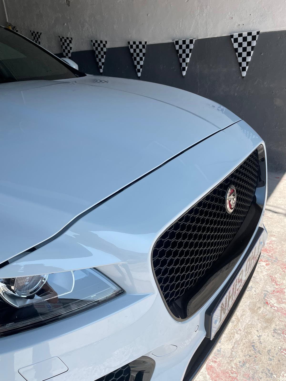 White car with custom grille and chequered flag detailing