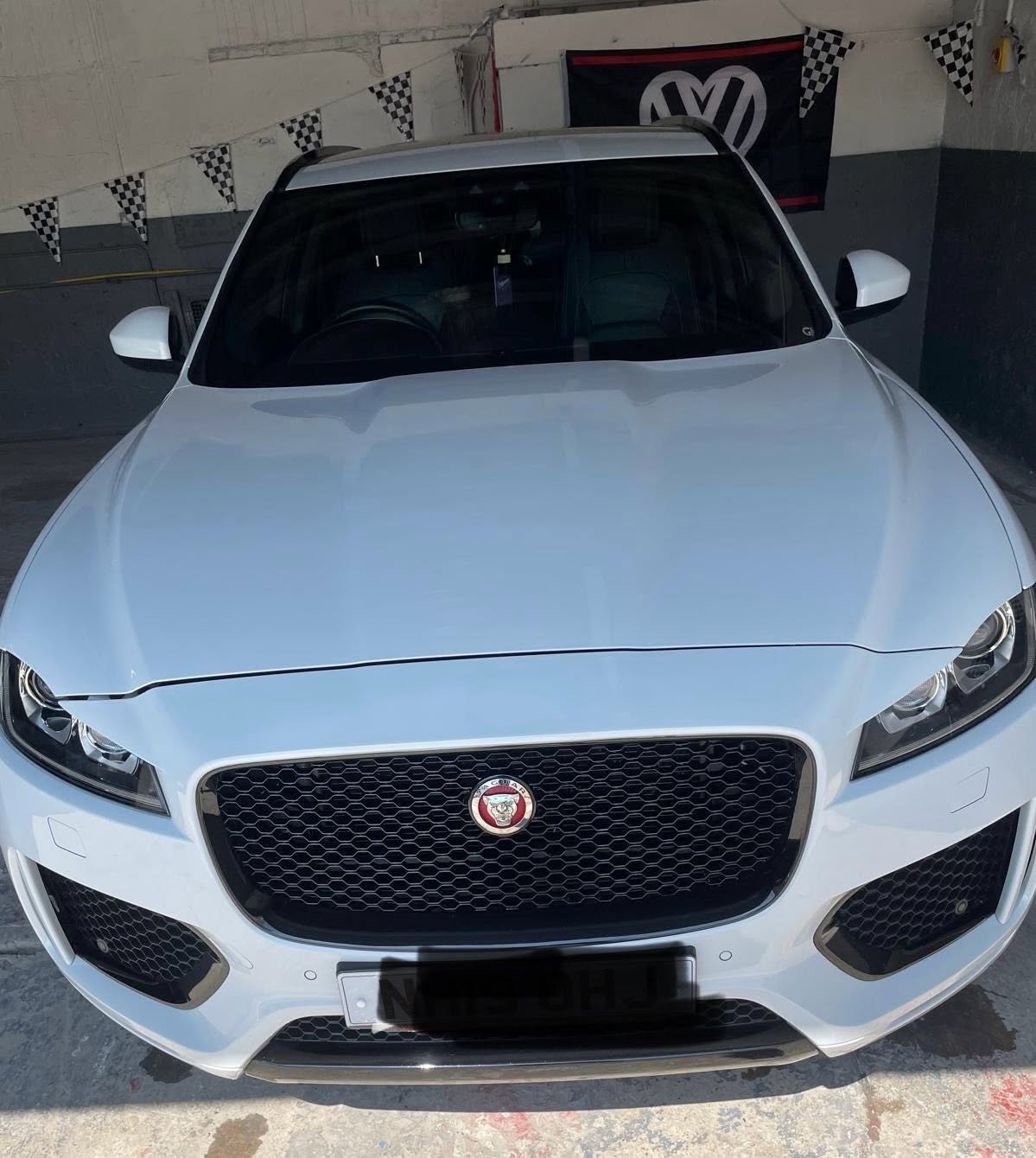 White Jaguar SUV front view in the garage