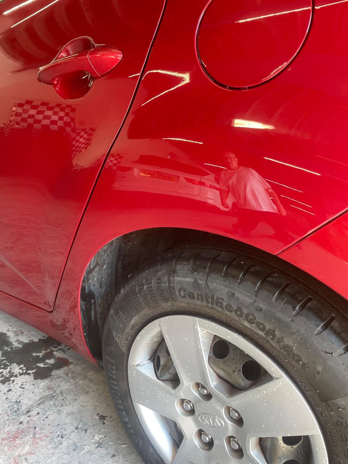 Red car body with Kia wheel visible