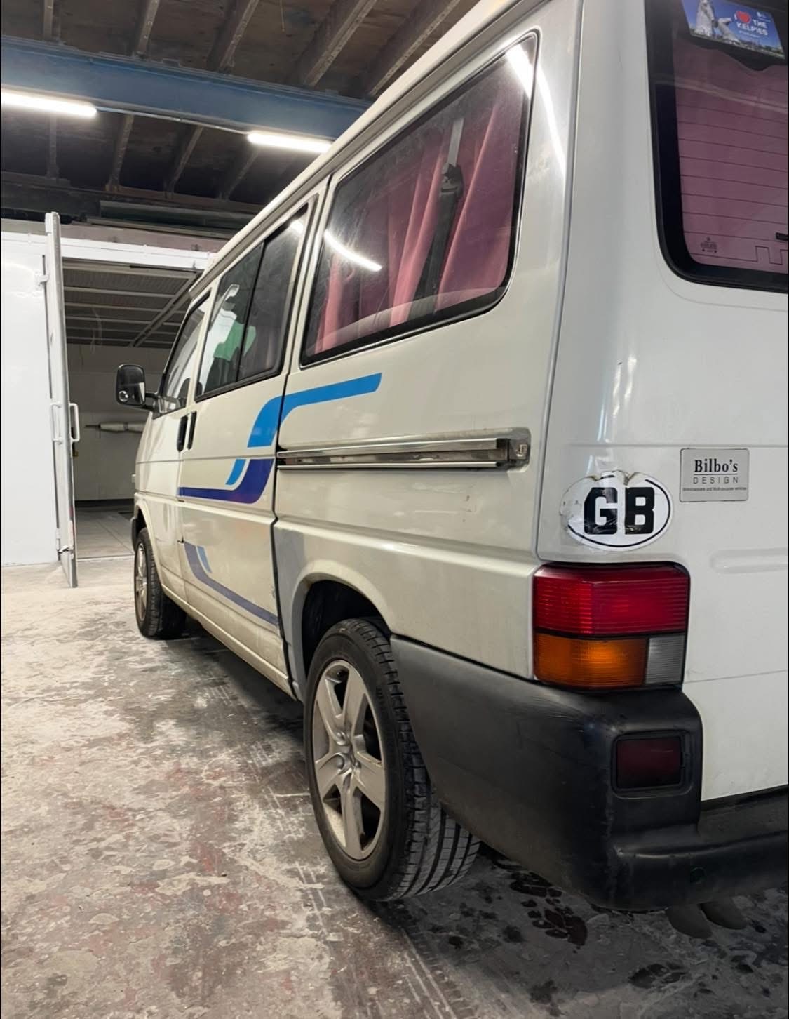 White VW van with custom blue swoosh graphics