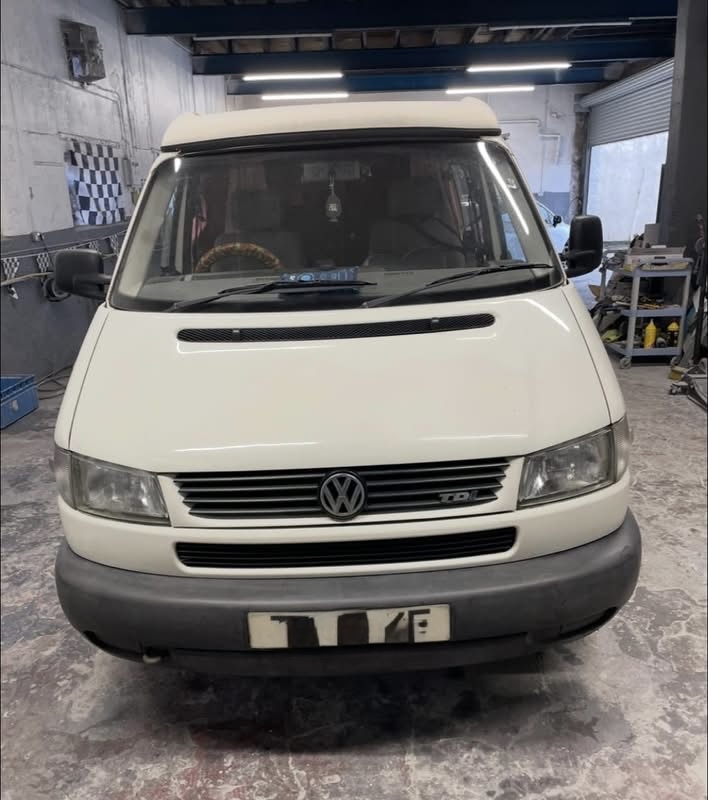 White VW campervan front view in the workshop